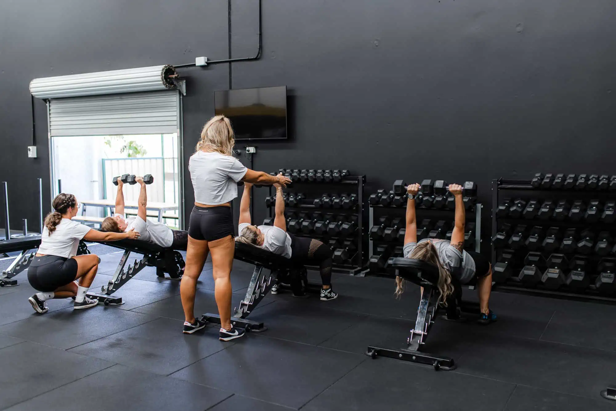 Women doing dumbbell press in ladies only gym