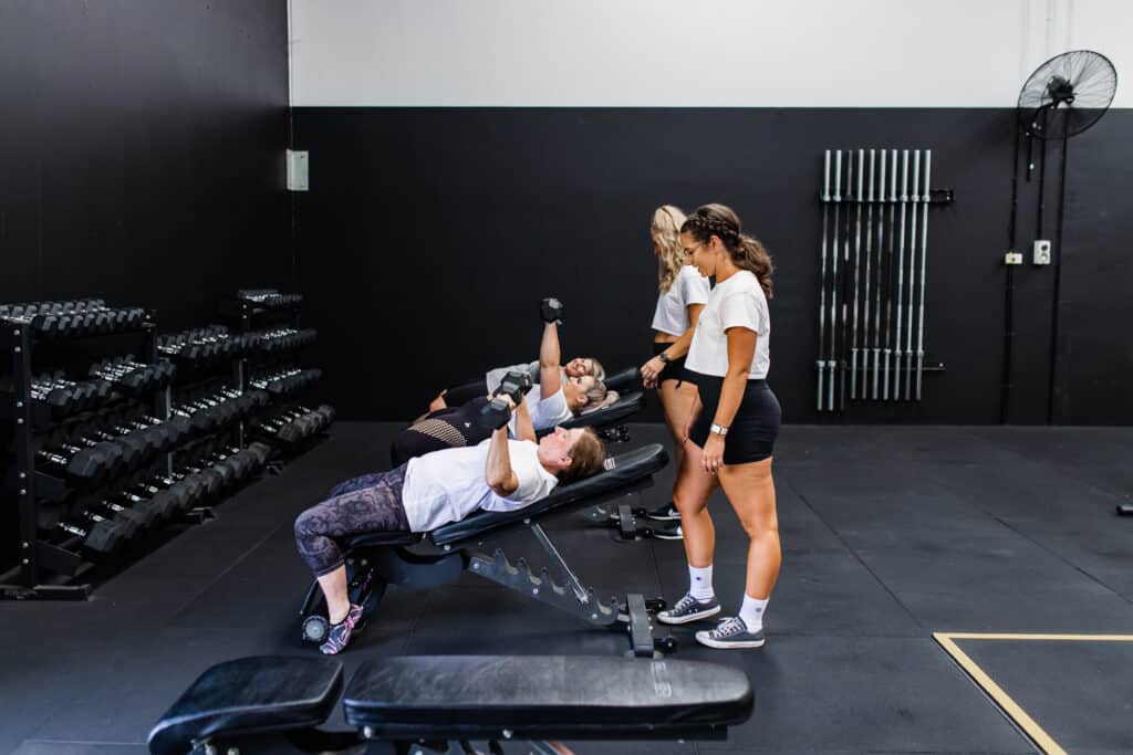 Ladies doing incline dumbbell press in women's only gym